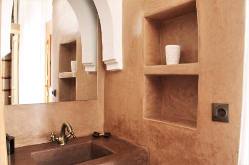 W łazience znajduje się umywalka i lustro. w obiekcie Riad Miski w Marakeszu