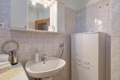 a bathroom with a sink and a mirror and a cabinet at Apartman D&D, Dvorine 63 in Banjole