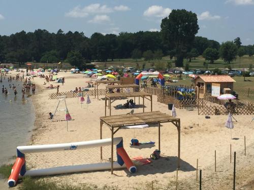 a group of people on a beach with umbrellas at Gite climatisé L'Orée des Landes Proche Center Parcs in Pindères