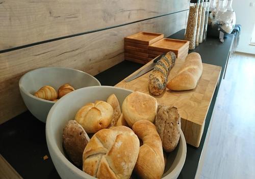 エルツァッハにあるHotel Restaurant Kochschule Rössleのテーブルの上に置かれたパンとロールパンのボウル