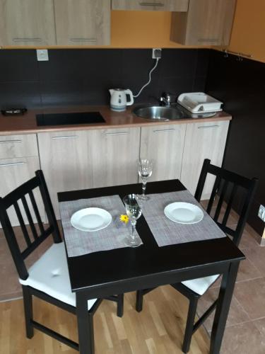 einem schwarzen Tisch mit 2 Stühlen und einem Tisch mit 2 Platten in der Unterkunft Midi in Posen