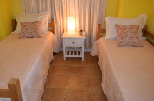 two beds in a room with a lamp on a table at Apart Hotel Terrazas de San Francisco in Piriápolis