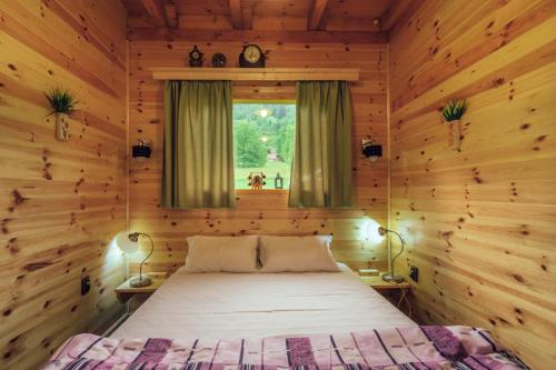 a bedroom with a bed in a wooden cabin at Chalet Tara in Mojkovac