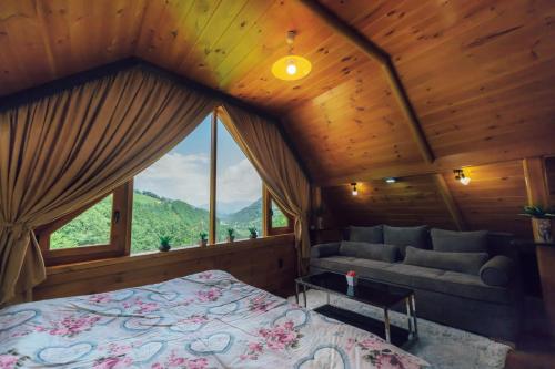 a bedroom with a bed and a large window at Chalet Tara in Mojkovac