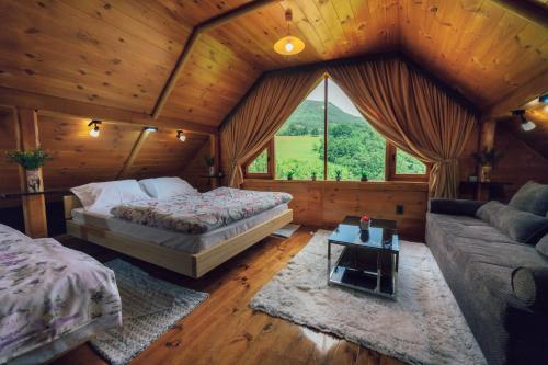 a bedroom with a bed and a couch in a cabin at Chalet Tara in Mojkovac