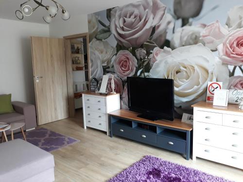 uma sala de estar com um grande mural de rosas em Sweet Garden Residence em Brasov