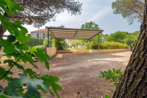 a pavilion in a park with a tree at Luna Apartment in Poreč
