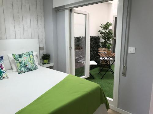 - une chambre avec un lit et une couverture verte dans l'établissement Casa Beiramar, parking gratuíto, à Vigo