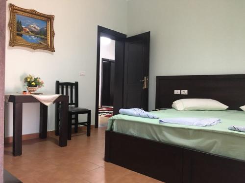 1 dormitorio con 1 cama, 1 mesa y 1 silla en Guest House Simeone, en Berat