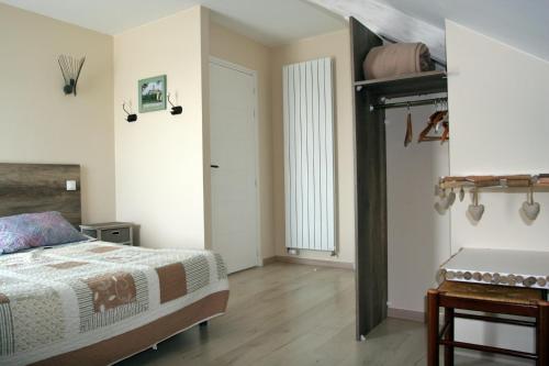 1 dormitorio con cama, mesa y puerta en Les 3 Vallées, en Saint-Florent-le-Vieil