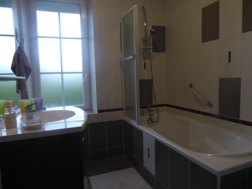 een badkamer met een groot bad en een wastafel bij Pause Couffy in Couffy