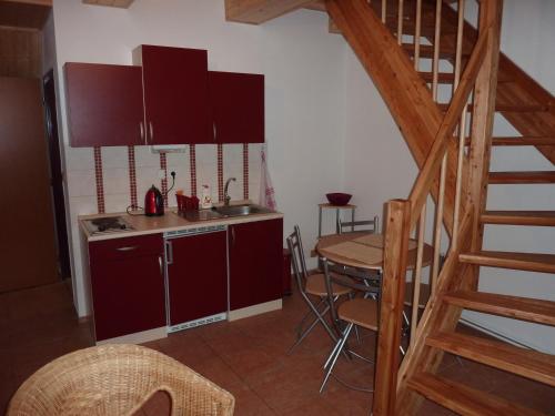 a kitchen with red cabinets and a table with chairs at Rodinny penzion Kunc in Slavonice