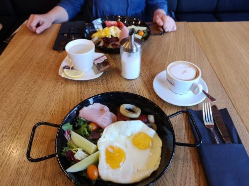 a table with two plates of breakfast food and coffee at Arkada Wadowice in Wadowice