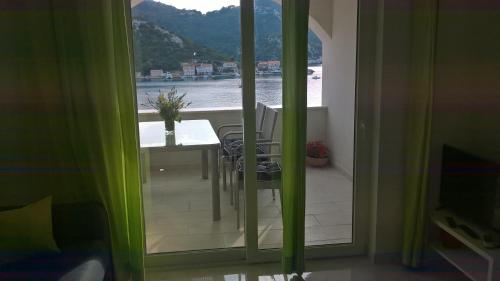a dining room with a table and a view of the water at Apartman Zaklopatica in Lastovo
