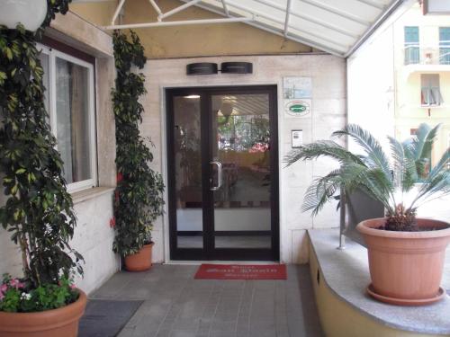 a front door of a store with potted plants at Hotel San Paolo in Varazze