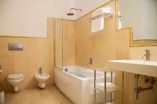 a bathroom with a tub and a toilet and a sink at Residenza dei Capitani in Ascoli Piceno