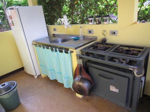 a kitchen with a stove and a sink and a refrigerator at Chalés Natora in Lençóis