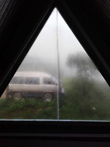 a view of a car in the rain through a window at White house in Nuwara Eliya