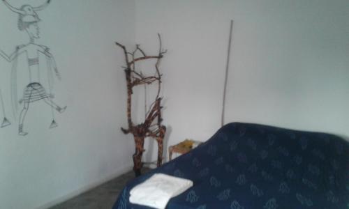 a room with a bed and a branch on the wall at Saldomar B&Biosphere in Bubaque
