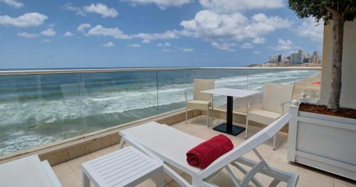 a balcony with a table and chairs and the ocean at Lancaster Eden Bay in Beirut