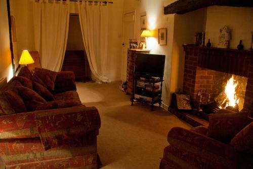 a living room with a fireplace and a couch and a television at The Old Stables B&B in Winslow