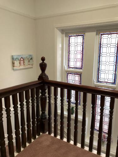 a staircase in a house with two windows at By The Sea Bed and Breakfast in Eastbourne