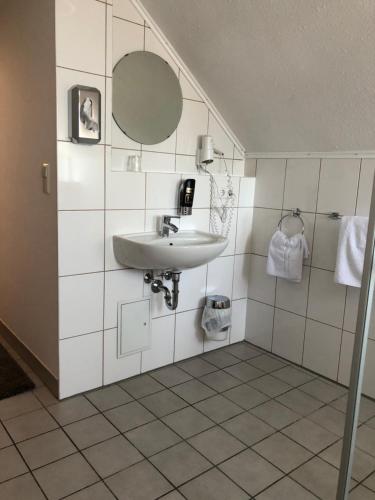 un baño con lavabo y espejo en Hotel Poseidon, en Ludwigsburg