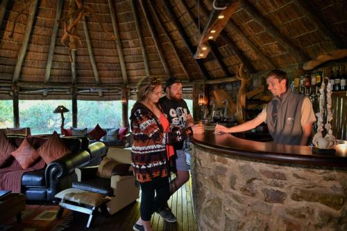 a group of people standing at a bar at Sibuya Game Reserve and Lodge in Kenton on Sea