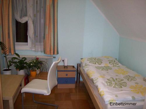 um quarto com uma cama, uma secretária e uma cadeira em Riedl Gästewohnung em Klagenfurt