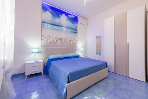 een slaapkamer met een bed en een schilderij aan de muur bij Cielo e Mare in Marina di Mancaversa