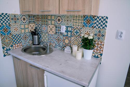 a kitchen counter with a sink and a refrigerator at Apartamenty Mewa in Międzyzdroje
