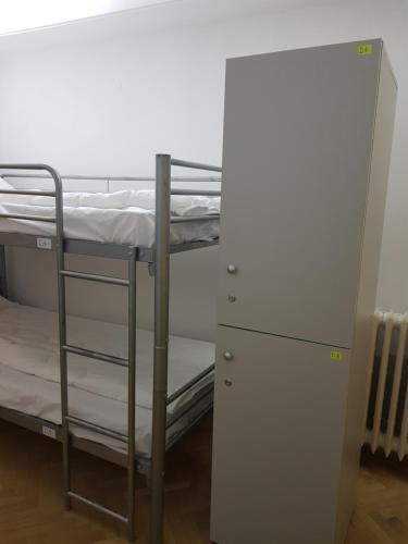 a room with two bunk beds and a refrigerator at Sleep Inn Hostel in Bucharest