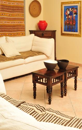 a living room with a couch and two bowls on a coffee table at Hotel Su Lithu in Bitti