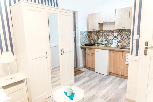 a kitchen with white cabinets and a blue arrow on the floor at Marina House Apartments in Międzyzdroje