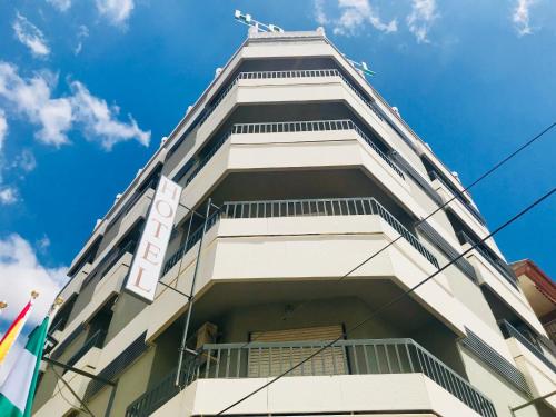 a tall white building against a blue sky at Hotel Fernando IV in Martos