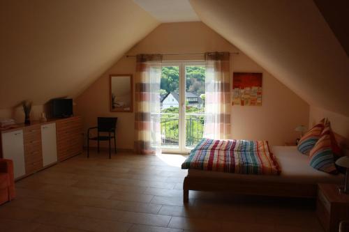 um quarto com uma cama e uma grande janela em Ferienhaus Trimmisch em Ediger-Eller