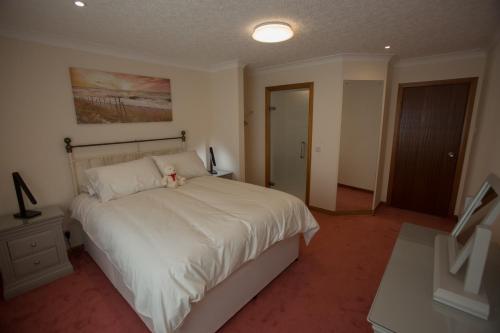 a bedroom with a bed with a teddy bear on it at GOLFVIEW 4 in Buckie