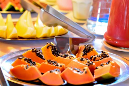 a plate of food with fruit on a table at Pousada Ana Terra in Monte Verde