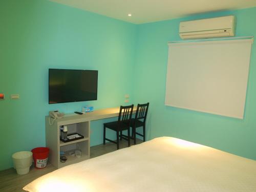 a bedroom with a desk with a television and a bed at Taimali Hotel in Taimali