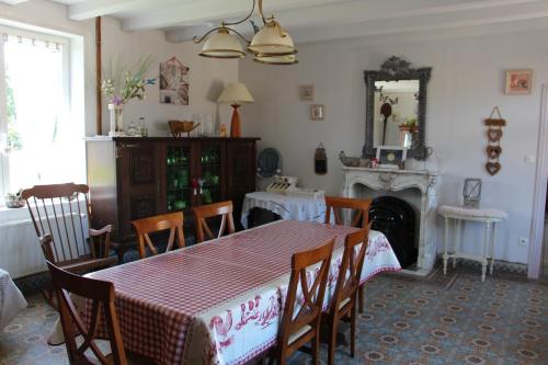 une salle à manger avec une table et des chaises et une cheminée dans l'établissement Ferme Du Pre Vert - Chambres d'hôtes B&B, à Nort-Leulinghem