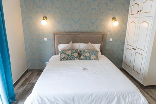 a bedroom with a white bed with blue wallpaper at Quinta Sao Martinho in Reguengo Grande