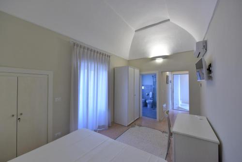 a white bedroom with a bed and a hallway at Fortino San Giorgio in Gallipoli