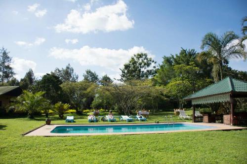 a swimming pool in a yard with a gazebo at Meru View Lodge in Usa River