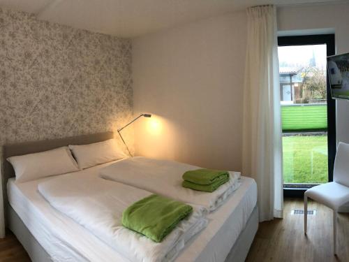 a bedroom with a bed with green pillows on it at Tor zum Meer in Helgoland