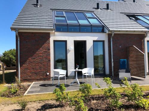 a house with two chairs and a table in front of it at Tor zum Meer in Helgoland