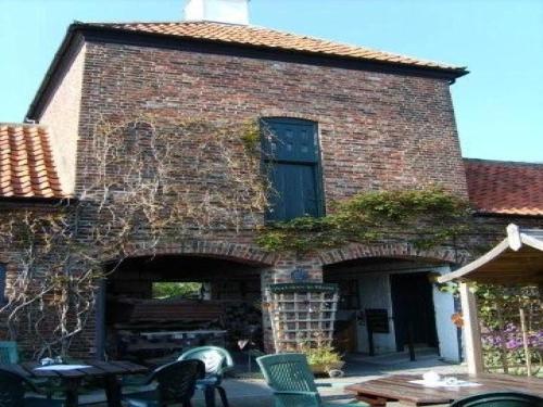 a large brick building with a table and chairs at Wolds Village Hotel in Bainton