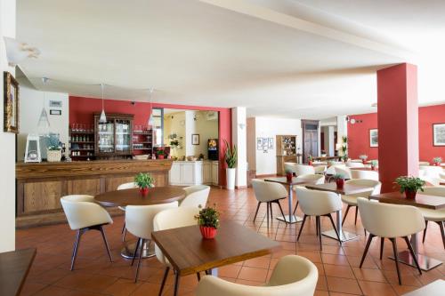 a restaurant with tables and chairs and a bar at Hotel & Restaurant Casolare Le Terre Rosse in San Gimignano