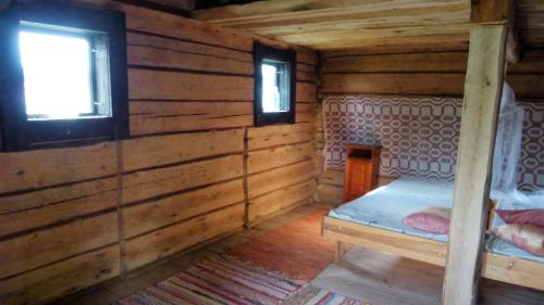 um quarto com uma cama num chalé de madeira em Vehmaanpirtti em Orivesi