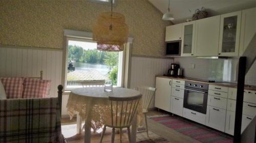 a kitchen with a table and a kitchen with a view at Vehmaanpirtti in Orivesi