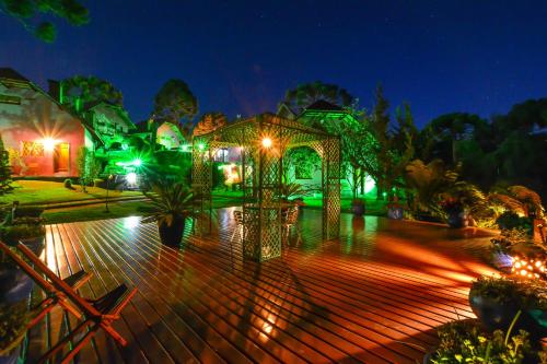 a garden with a gazebo at night at Pousada Ana Terra in Monte Verde
